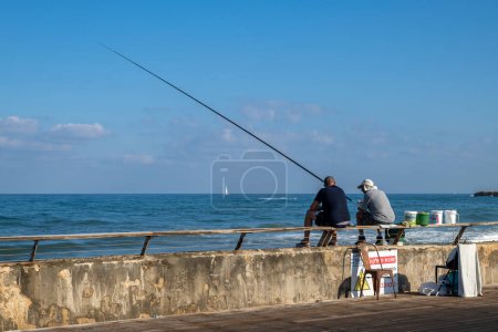 Foto de Tel Aviv, Israel Septiembre 10, 2022 Dos amigos pescando en el puerto de Tel Aviv Israel un sábado por la mañana. - Imagen libre de derechos