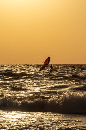 Photo for A man in silhouette on a hydrofoil kite board at sunset in Atlit, Israel. - Royalty Free Image