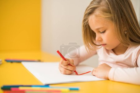Photo for Beautiful little girl enjoys drawing at her home. - Royalty Free Image