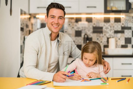 Photo for Little girl and her father enjoy drawing together at their home. - Royalty Free Image