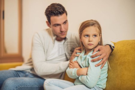 Téléchargez les photos : Petite fille est en colère après un conflit avec son père et il essaie de la réconforter. - en image libre de droit