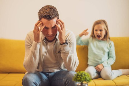 Photo for Stressed father is  feeling desperate because of  screaming  his daughter. - Royalty Free Image