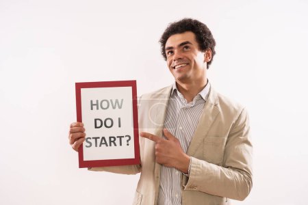 Téléchargez les photos : Image of  businessman  holding paper with text how do I start. - en image libre de droit