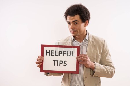 Foto de Image of businessman holding paper with text helpful  tips . - Imagen libre de derechos