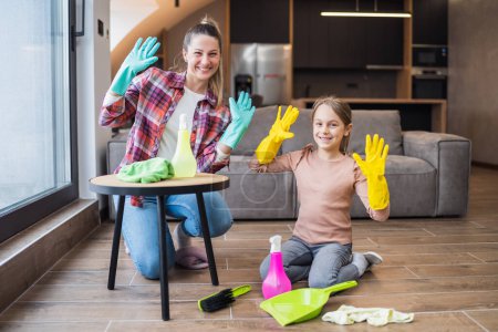 Téléchargez les photos : Mère heureuse et fille nettoyage maison ensemble. - en image libre de droit