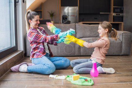 Téléchargez les photos : Bonne mère et fille s'amusent tout en nettoyant la maison ensemble. - en image libre de droit