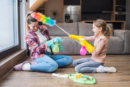 Téléchargez les photos : Bonne mère et fille s'amusent tout en nettoyant la maison ensemble. - en image libre de droit