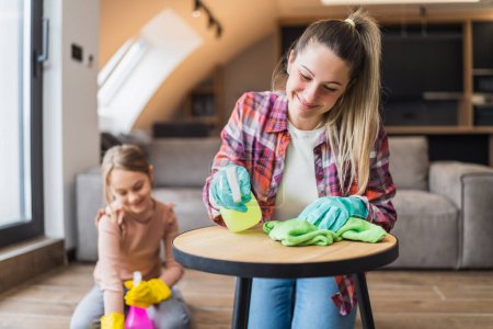 Photo for Happy mother and daughter cleaning house together. - Royalty Free Image
