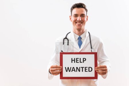 Photo for Image of doctor holding a paper with a text help wanted. - Royalty Free Image