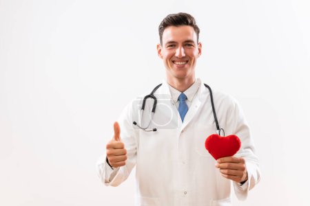 Téléchargez les photos : Image d'un jeune médecin montrant la forme du cœur et le pouce levé. - en image libre de droit