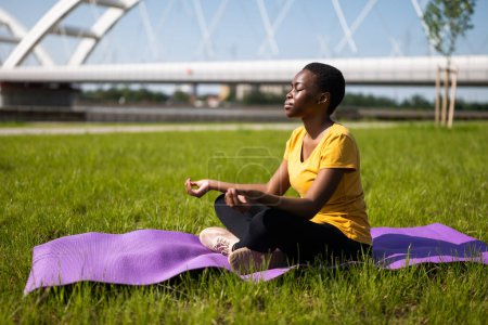 Photo for Young woman enjoys meditating outdoor. - Royalty Free Image