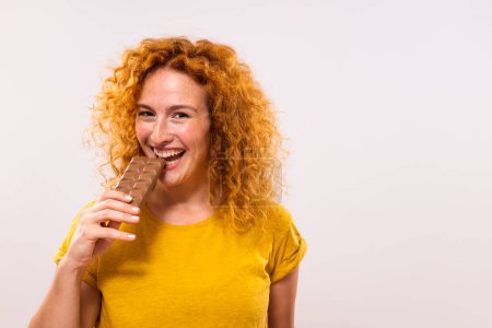 Téléchargez les photos : Portrait de femme gingembre mignon heureux aime manger du chocolat. - en image libre de droit