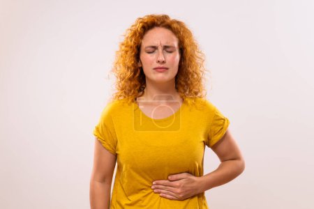 Téléchargez les photos : Gingembre femme ayant des douleurs dans l'estomac. - en image libre de droit