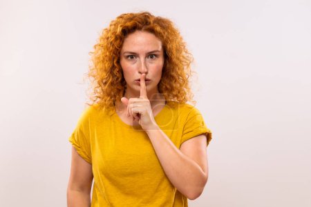 Photo for Portrait of a beautiful ginger woman with finger on her lips. - Royalty Free Image