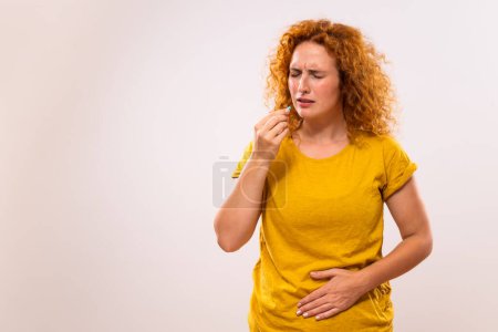 Téléchargez les photos : Ginger femme prend des pilules pour les maux d'estomac. - en image libre de droit