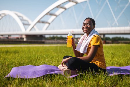 Foto de Mujer deportiva bebiendo bebida energética mientras descansa después del ejercicio. - Imagen libre de derechos