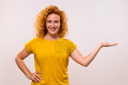 Foto de Imagen de una hermosa mujer pelirroja mostrando la palma de la mano sobre fondo gris. - Imagen libre de derechos