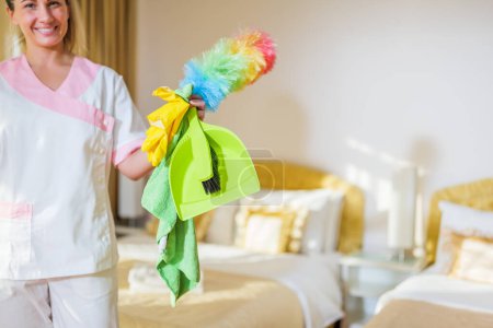 Téléchargez les photos : Fermer l'image de l'équipement de nettoyage tenant la femme de chambre d'hôtel dans la chambre. - en image libre de droit