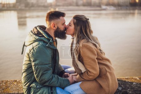 Téléchargez les photos : Couple heureux baisers tout en appréciant passer du temps ensemble en plein air. - en image libre de droit