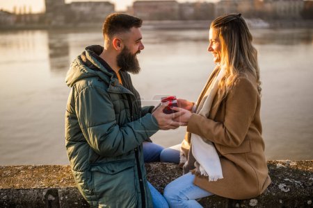 Téléchargez les photos : Femme donnant des cadeaux à son homme alors qu'ils aiment passer du temps ensemble en plein air. - en image libre de droit