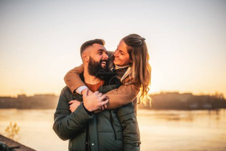 Téléchargez les photos : Heureux couple profiter de passer du temps ensemble en plein air sur un coucher de soleil. - en image libre de droit
