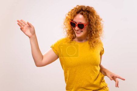 Téléchargez les photos : Image de femme gingembre heureux avec des lunettes de soleil en forme de coeur rouge. - en image libre de droit