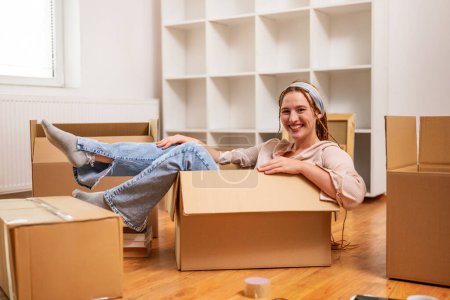 Photo for Happy woman having fun while moving into new apartment. - Royalty Free Image