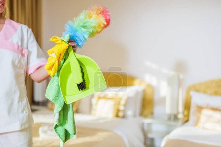 Téléchargez les photos : Fermer l'image de l'équipement de nettoyage tenant la femme de chambre d'hôtel dans la chambre. - en image libre de droit