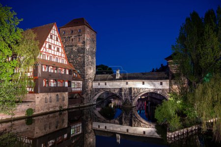 Foto de Antiguo puente medieval por la noche sobre el río Pegnitz en Nuremberg, Alemania. Puente del ahorcado. - Imagen libre de derechos