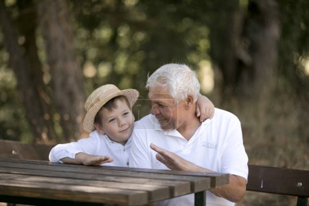 Foto de Happy senior man Grandfather with cute little boy grandson playing in forest - Imagen libre de derechos