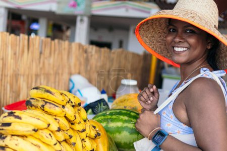 Photo for Beautiful woman at farmer's market wearing sun hat and holding reusable tote bags - Royalty Free Image