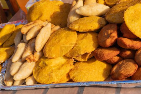 Close-up of assorted fried snacks from a Latin American street food vendor.