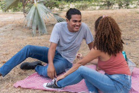Ein Paar genießt einen verspielten Moment auf einer Picknickdecke.