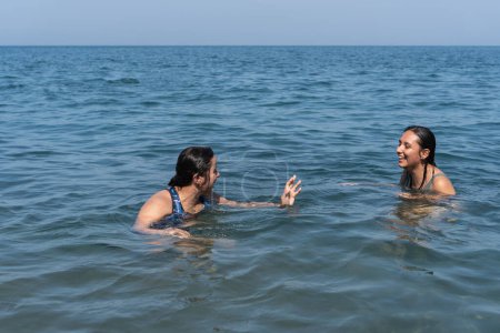 Two people chatting and laughing in the sea.