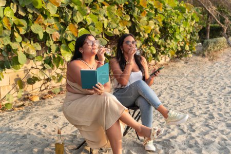 Friends unwinding with wine and a book by the beach.
