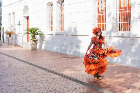 Fröhliche Frau tanzt Cumbia im Freien in Kolumbien
