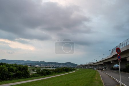 Photo for View of highway and town surrounded by mountains in a cloudy day during afternoon (Ikeda, Osaka, Japan) - Royalty Free Image