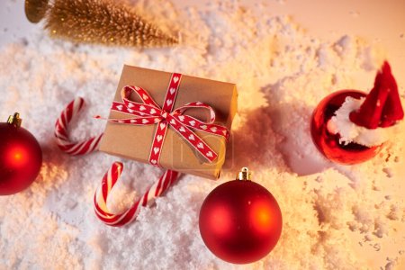 Téléchargez les photos : Concept de Noël, traîneau Santas en cadeau rouge et cannes à bonbons sur fond rouge, cadeau pour les vacances d'hiver, espace de copie - en image libre de droit