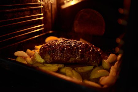 Foto de Cocinar comida casera en un horno eléctrico. Carne con patatas, carne y hierbas - Imagen libre de derechos