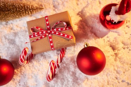 Téléchargez les photos : Concept de Noël, traîneau Santas en cadeau rouge et cannes à bonbons sur fond rouge, cadeau pour les vacances d'hiver, espace de copie - en image libre de droit
