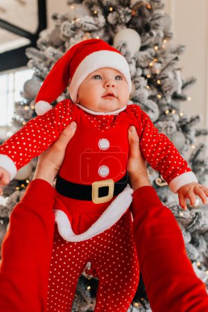 Foto de Bebé en el fondo de un árbol de Navidad. - Imagen libre de derechos