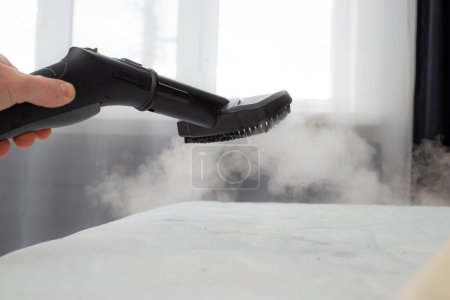 Photo for Cleaning mattress with professional equipment in bedroom, closeup. - Royalty Free Image