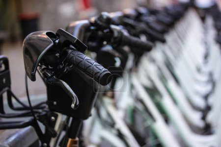 Foto de Un montón de bicicletas blancas de pie en una fila en el estacionamiento de bicicletas. Alquilar y compartir bicicletas. Transporte ecológico para los deportes, viajar en una ciudad. Alquiler de transporte verde. Manillar, ruedas, marcos de bicicleta - Imagen libre de derechos
