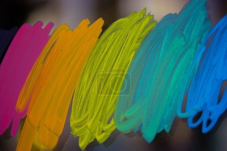 Coups lumineux multicolores de peinture acrylique sur le verre. LGBT, couleurs LGBTIQ. Drapeau arc-en-ciel, drapeau de la communauté transgenre papier peint abstrait. Symbole de communauté gay. Cours de dessin à l'école d'art. 