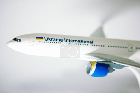 Photo for Kyiv, Ukraine. 1 May 2022 A nose of a white toy airplane of the Ukraine International company, airliner on a white background. Aircraft transportation for traveling trips, airpots. Model plane details - Royalty Free Image