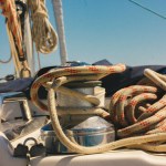 Anchor winch for boats blue rope ropes on the ocean background. Sea travel in summer, adventure, voyage. Ships and yachts details. Pier for mooring. Vintage marina theme. Luxury summertime vacations. 