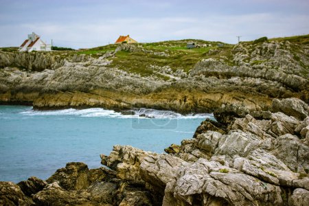 Photo for Beaches of a Costa de Cantabria, North of Spain, Santander Picturesque beach, rocks stones in waters of Atlantic Ocean. Travel destination, tourism in summer. Houses on a rocky bay in gloomy day. - Royalty Free Image