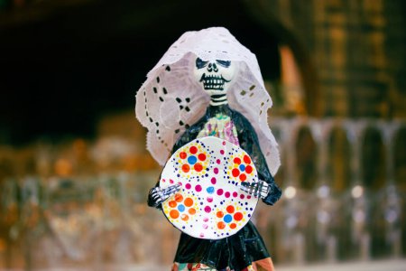 Photo for Figure of a Mexican Catrina with a colorful plate. Decor for Day of dead. Mexican cuisine. Decoration from Mexico. 2 of November symbol of Latin America and Hispanic culture. Mexican skeleton. - Royalty Free Image