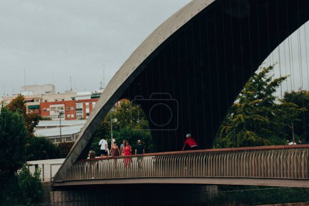 Téléchargez les photos : Madrid, Espagne. 1 mai 2022 Pont piétonnier en béton suspendu avec des personnes à Rio Madrid. Infrastructures urbaines dans le parc municipal. Les gens dans une rue de la ville. - en image libre de droit