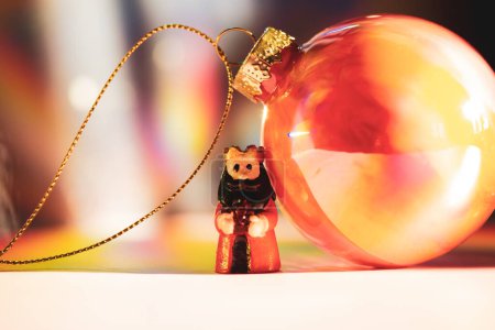 Une figurine couronnée roi, une boule rouge sapin de Noël. Décor saisonnier pour le Nouvel An. Fête d'hiver jouets fond avec espace de copie. Carte postale Vacances